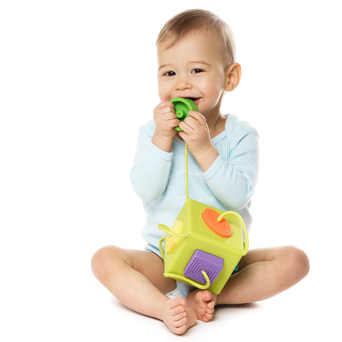 Smiling baby in a romper playing with a soft activity toy